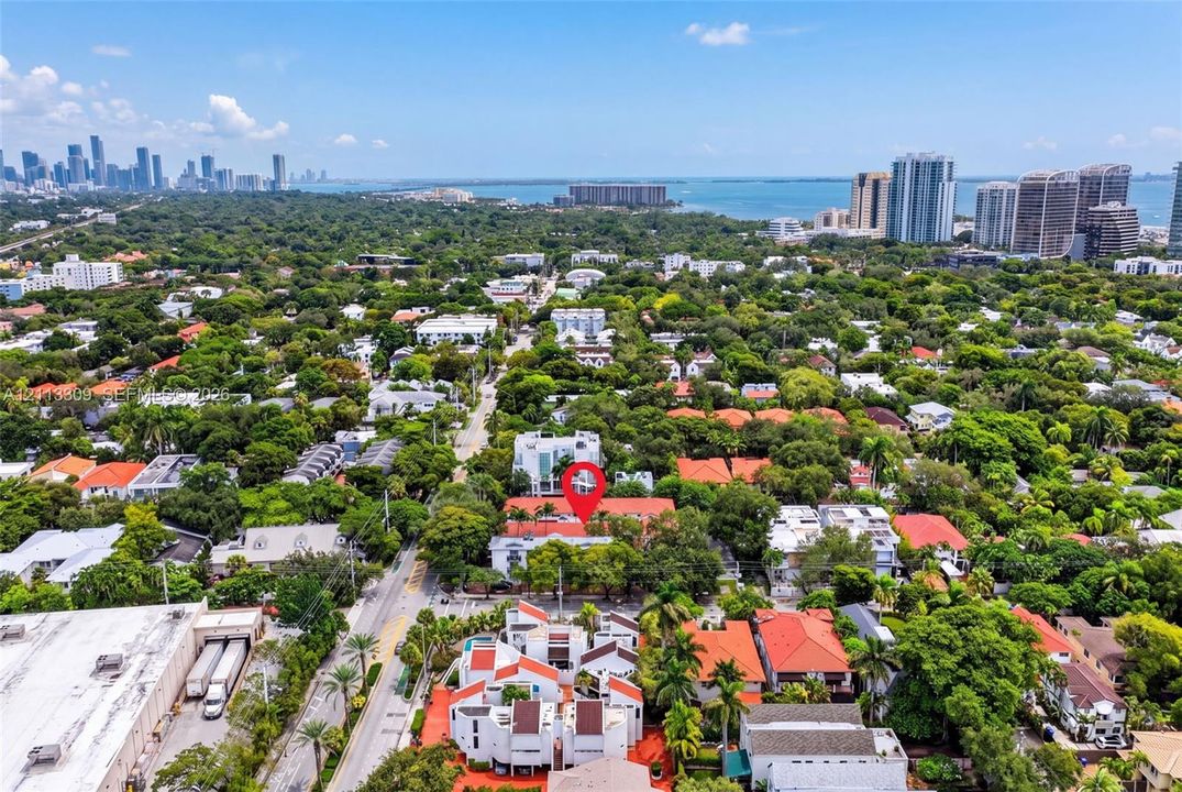 Aerial perspective of the property featuring a dense canopy of mature trees and proximity to the coastline and urban skyline