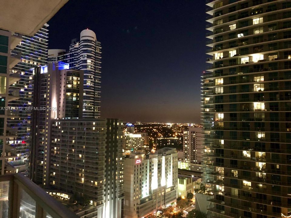 High-rise balcony featuring a metal railing and an expansive urban cityscape backdrop