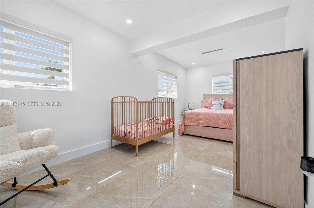 Large-format tile flooring, recessed ceiling lighting, and windows featuring dual-layer shade systems