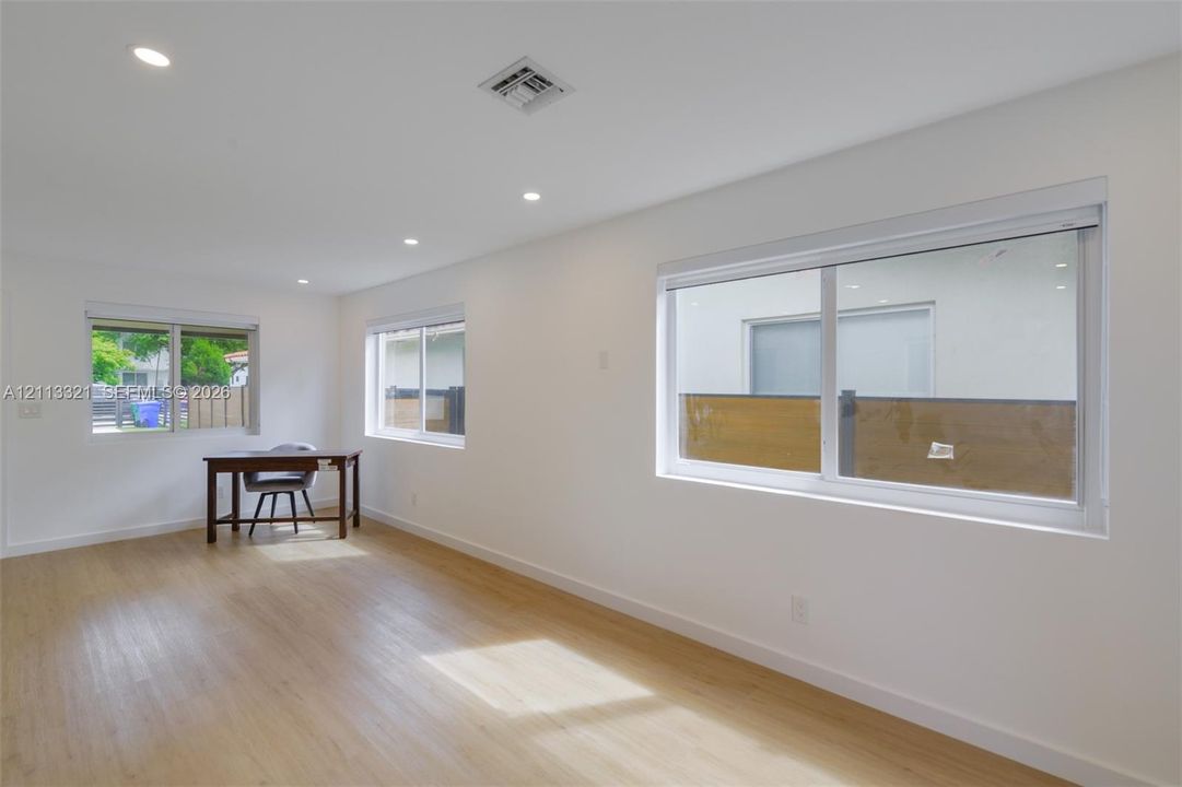 Interior space featuring light wood-finish flooring, recessed lighting, and multiple sliding windows
