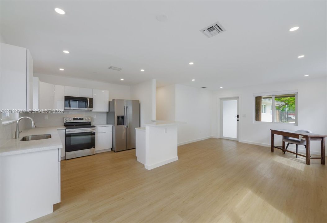 Kitchen featuring white cabinetry, stone countertops, stainless steel appliances, recessed lighting, and wood-finish flooring