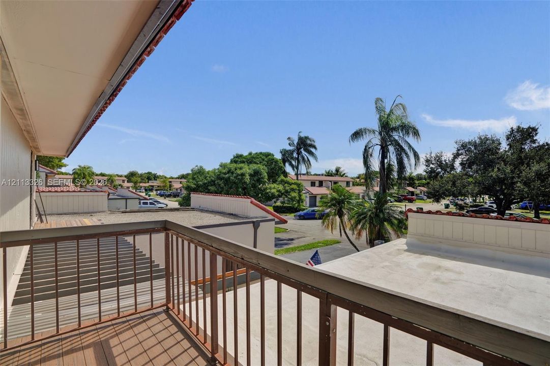 Elevated balcony featuring wood-finish decking and metal railings