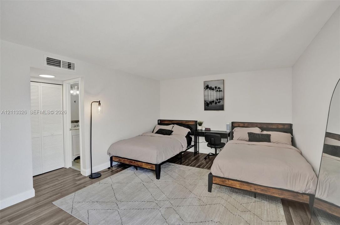 Wood-finish flooring and white louvered closet doors