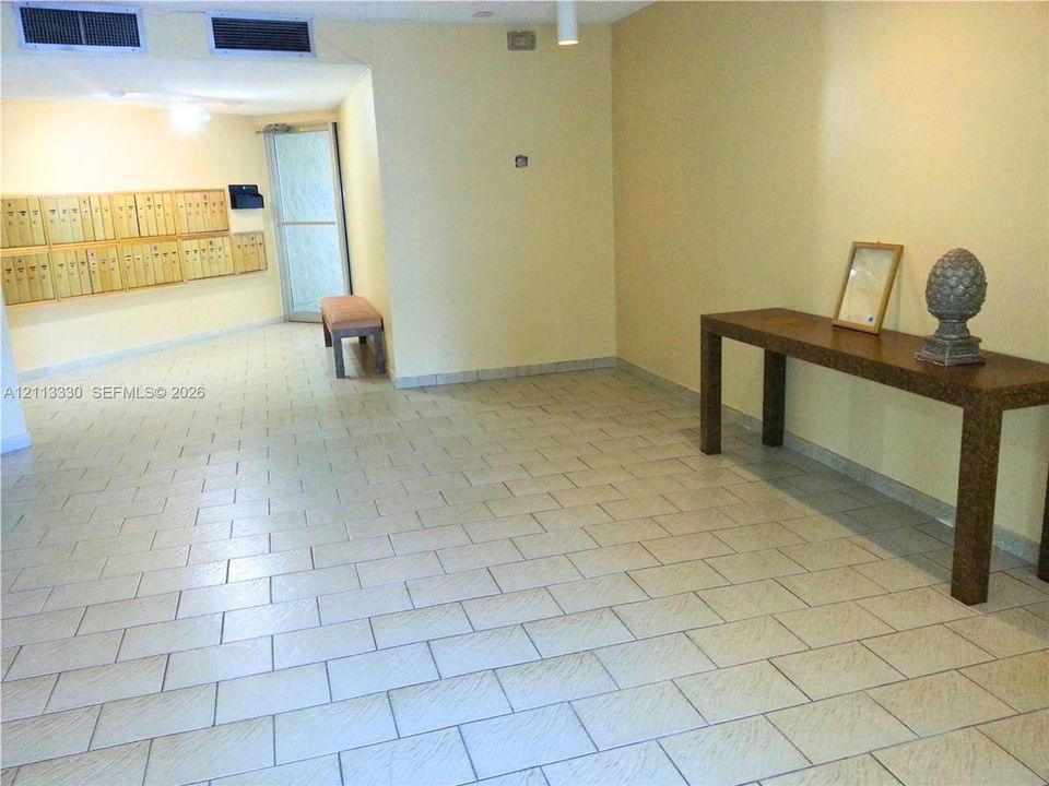 Common area featuring large-format ceramic tile flooring, recessed ceiling lighting, and integrated wall-mounted mailboxes