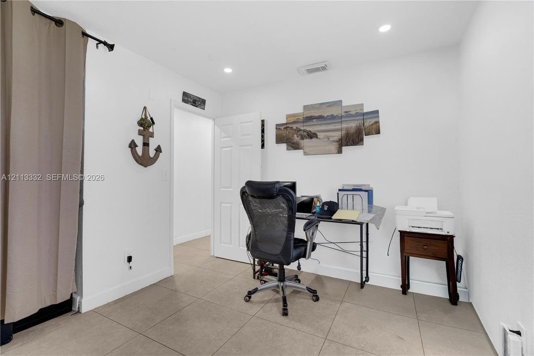 Neutral wall paint, large-format tile flooring, and recessed ceiling lighting
