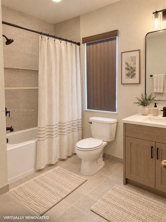 Bathroom featuring a vanity with a light wood-finish cabinet and solid surface countertop, matte black hardware, tile shower surround with integrated shelving, and large-format floor tile