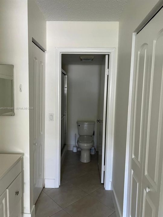 Bathroom featuring tile flooring, a built-in vanity, and dual bi-fold closet doors