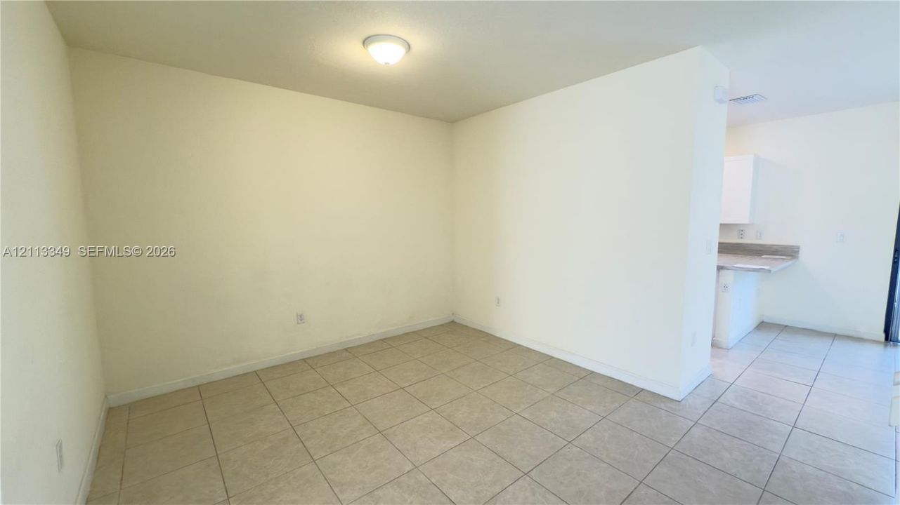 Neutral-toned tile flooring, white wall finishes, and a flush-mount ceiling light fixture