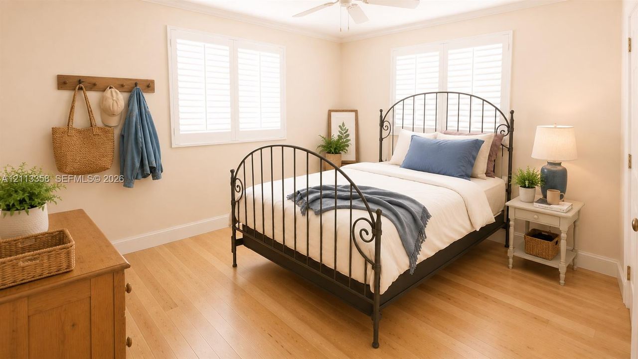 Light-filled room featuring wood-finish flooring, plantation shutters, and a ceiling fan