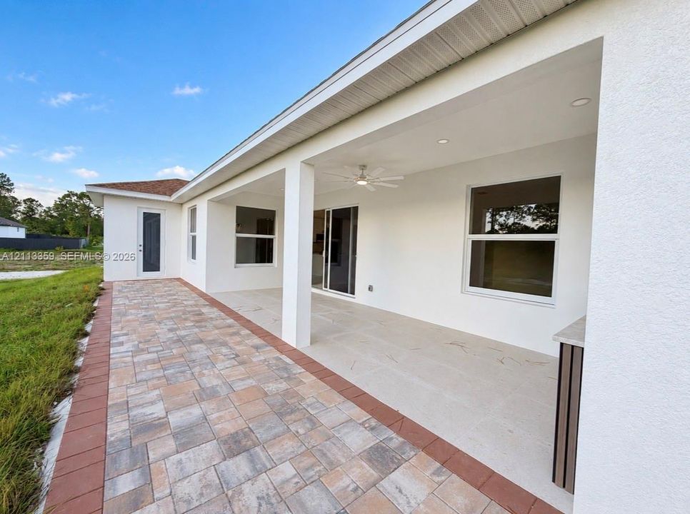 Covered patio with recessed lighting, integrated ceiling fan, paver flooring, and built-in exterior cabinet