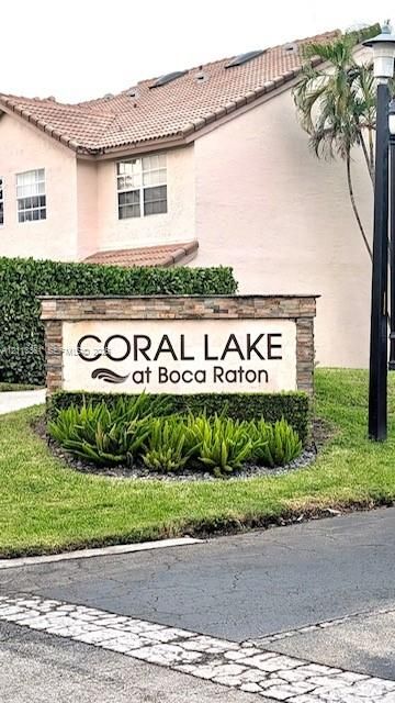 Community entrance signage featuring stone-veneer pillars and integrated landscaping with manicured shrubbery