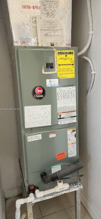 Rheem Classic furnace unit featuring insulated refrigerant piping and PVC condensate drainage plumbing