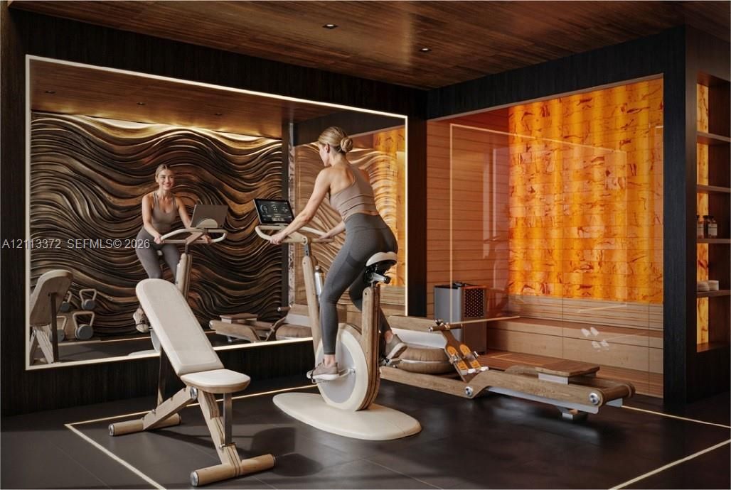 Fitness room featuring a textured wave-pattern feature wall, backlit amber-toned wall panel, wood-finish ceiling, large mirror, and built-in shelving