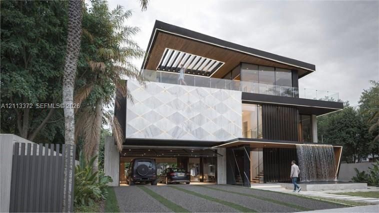 Contemporary multi-level exterior featuring a geometric stone facade, integrated water feature, wood-paneled ceiling overhangs, expansive glass curtain walls, and a glass-railed upper-level terrace