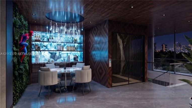 Interior space featuring a backlit stone-slab bar, wood-paneled ceiling, integrated elevator with dark stone surround, and vertical botanical wall installation
