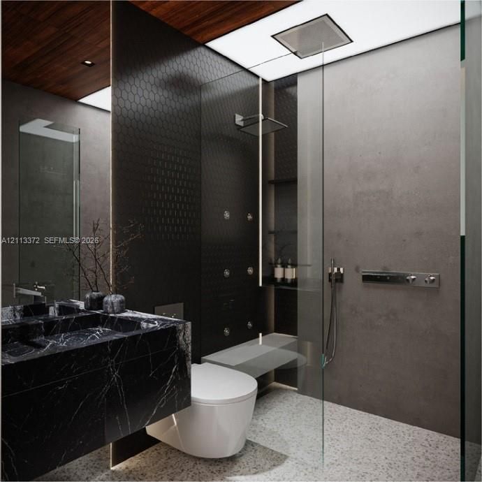 Custom floating vanity with a dark stone finish, walk-in shower featuring a recessed rain showerhead and body sprays, floor-to-ceiling glass enclosure, matte-finish wall tiles, and wood-finish ceiling detailing