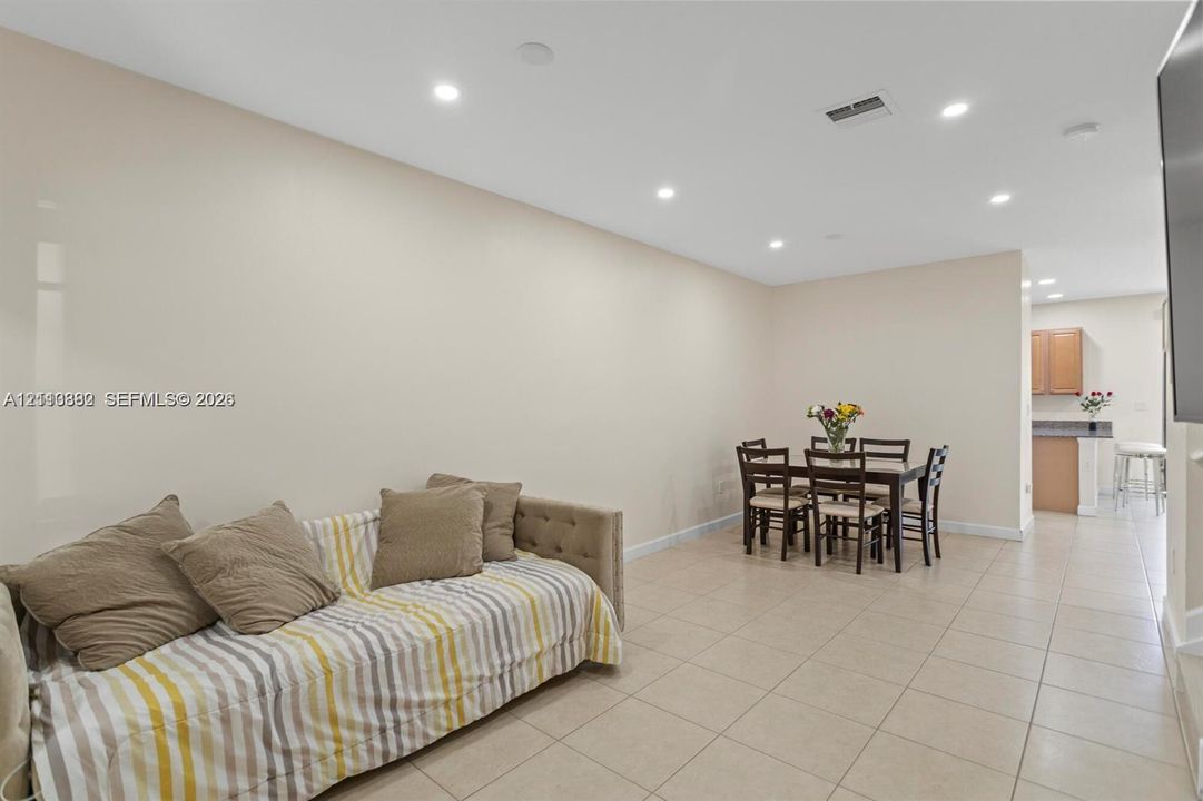 Open-concept interior featuring light-toned floor tile and recessed ceiling lighting