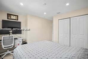 Recessed ceiling lighting, dual-panel closet doors, and neutral wall tones