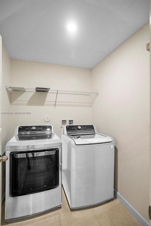 Laundry closet featuring tile flooring and wall-mounted wire shelving
