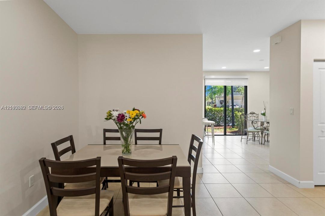 Neutral-toned interior featuring ceramic tile flooring, recessed ceiling lighting, and sliding glass doors with exterior access