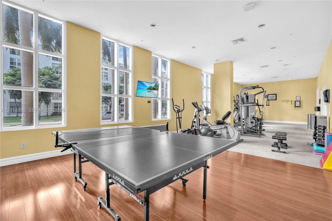 Fitness center featuring floor-to-ceiling windows, wood-finish flooring, and recessed ceiling lighting