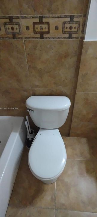 Full-height wall tile with decorative accent border and matching floor tile