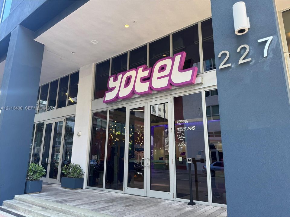 Commercial storefront featuring floor-to-ceiling glass paneling, metal-framed doors, and high-contrast dark exterior finishes