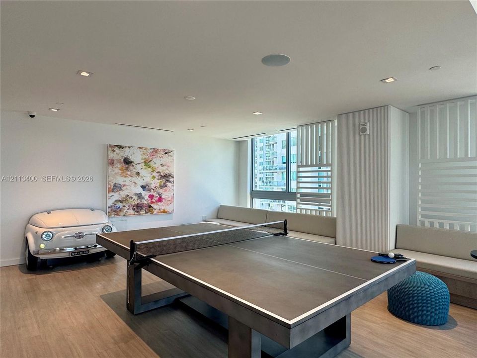 Light-filled interior featuring wood-finish flooring, recessed lighting, integrated ceiling speakers, and built-in bench seating