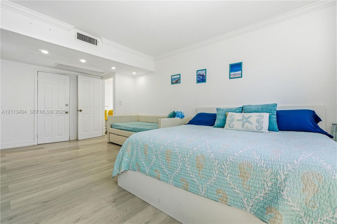 Wood-finish flooring, recessed lighting, and crown molding