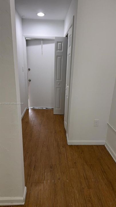 Entryway featuring wood-finish flooring, recessed ceiling lighting, and a paneled closet door
