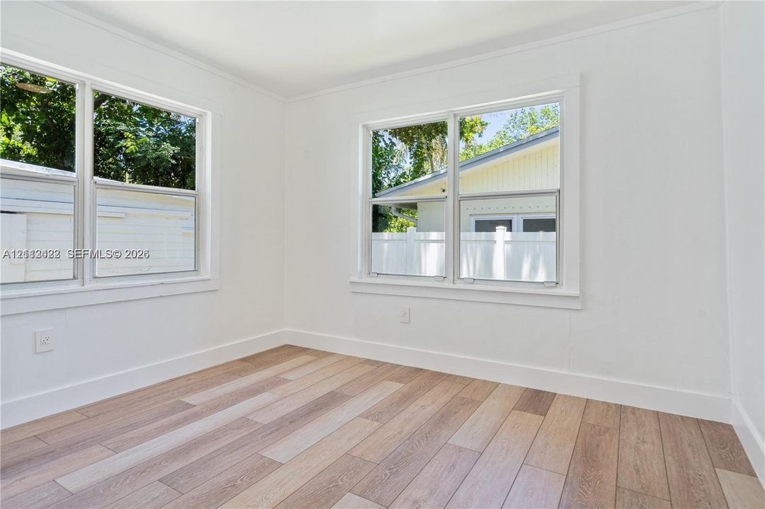 Bright interior space featuring wood-finish flooring, neutral walls, and dual double-pane windows