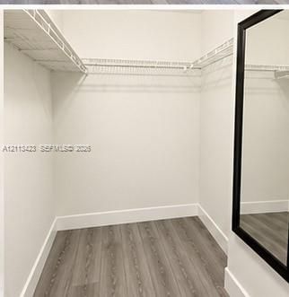 Walk-in closet featuring wood-finish flooring and white wire shelving
