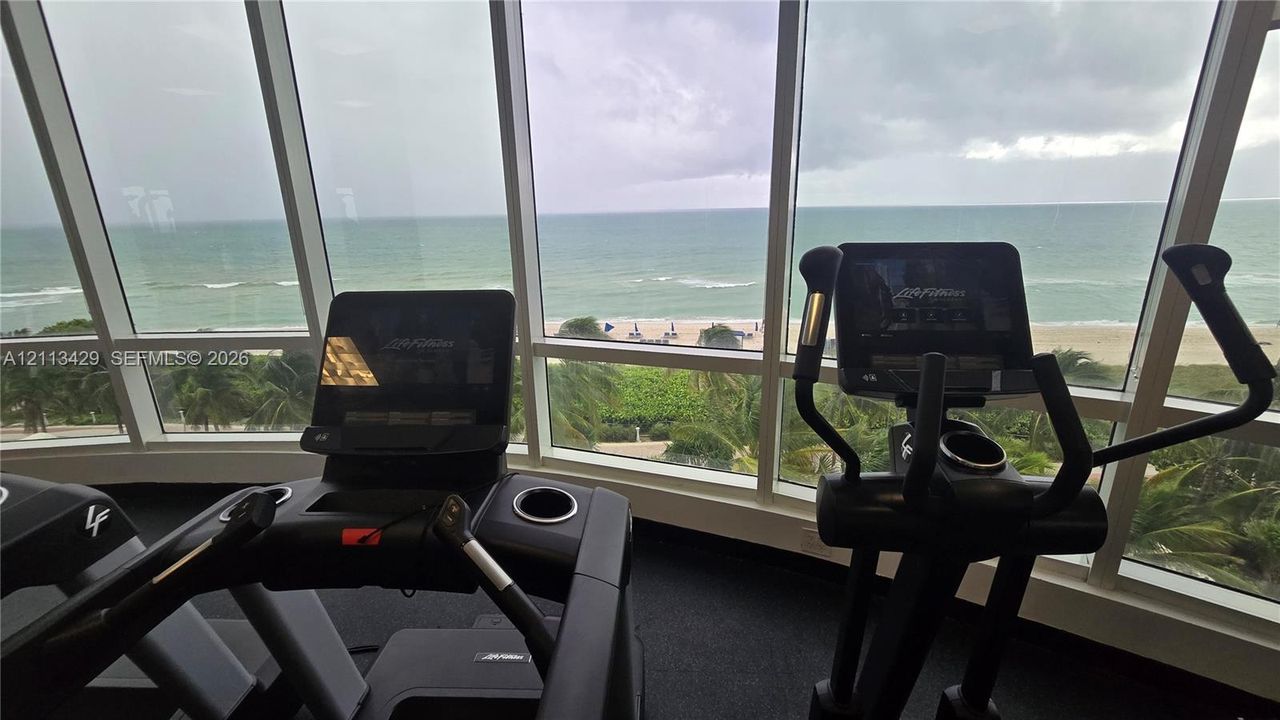 Fitness center featuring floor-to-ceiling windows and coastal scenery