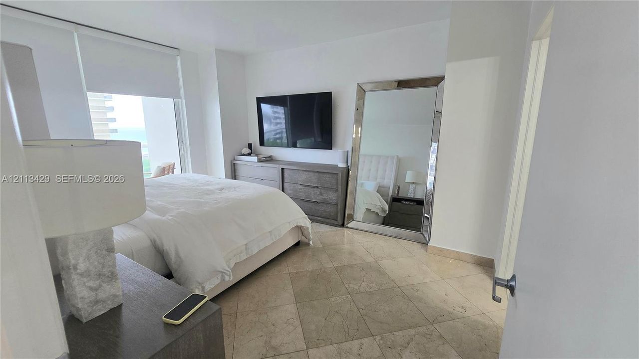 Natural stone tile flooring, floor-to-ceiling window, and neutral wall palette