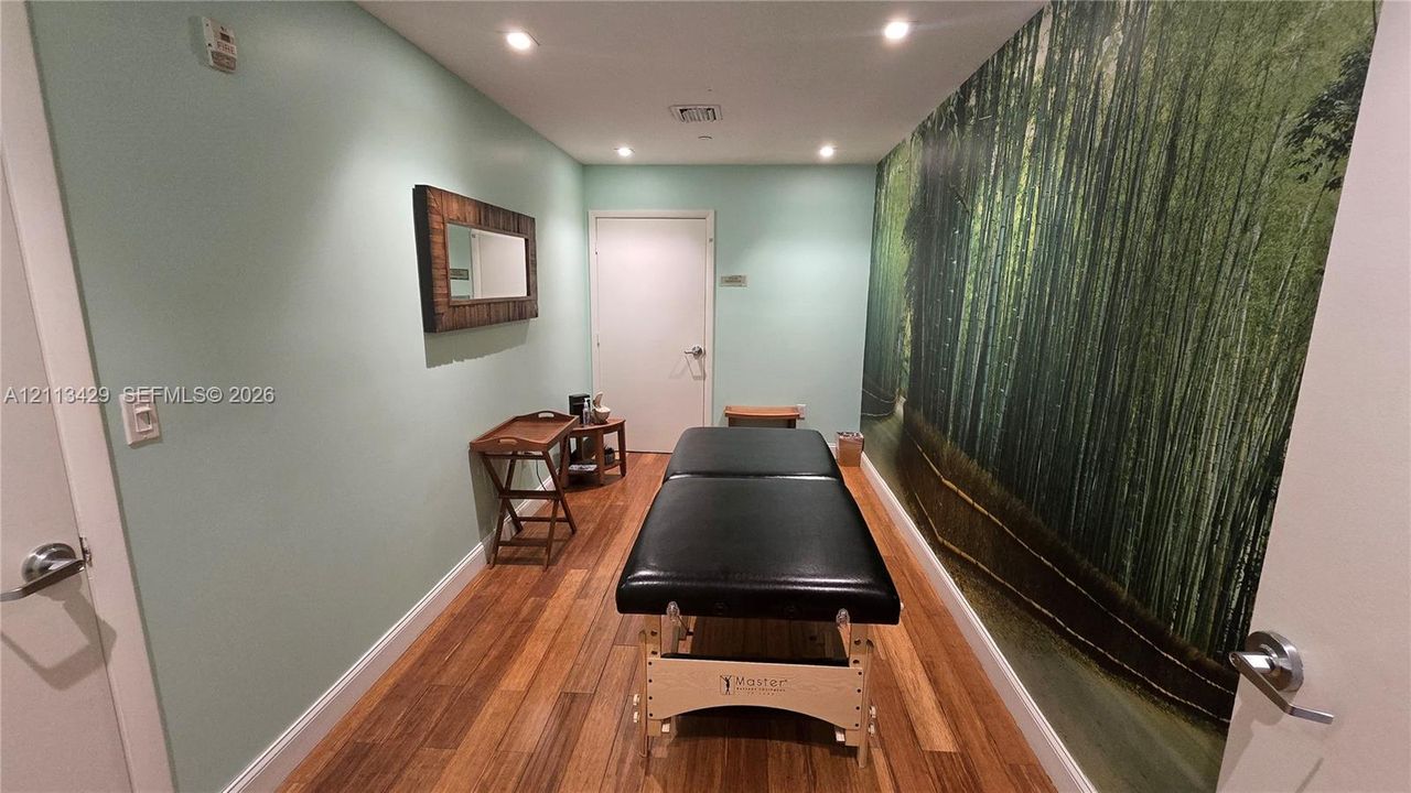 Room featuring wood-finish flooring, recessed lighting, and a large-scale graphic wall mural