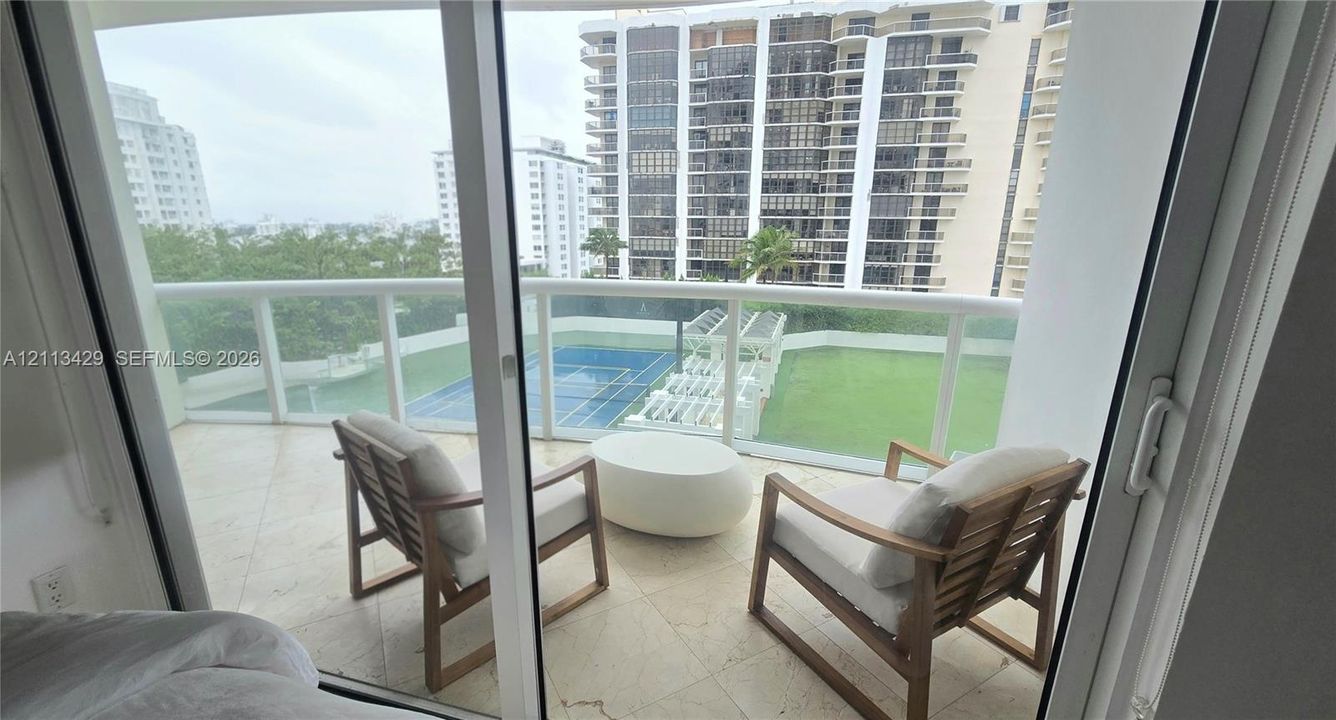 Private balcony featuring tile flooring and a glass-paneled railing