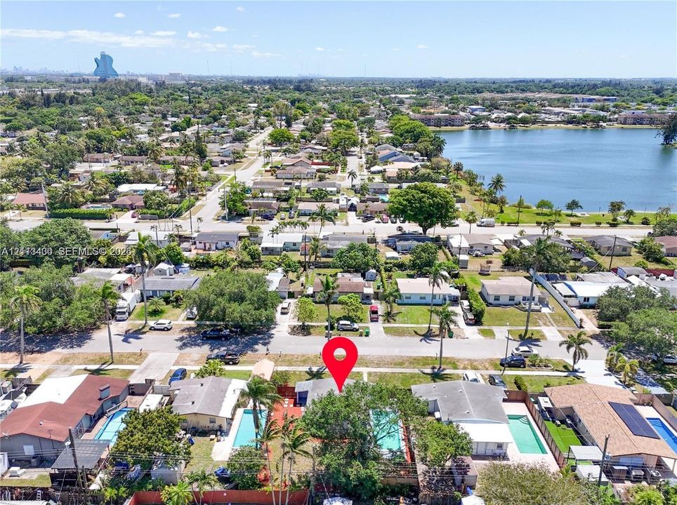 Aerial perspective of residential property featuring a private swimming pool, fenced perimeter, and mature canopy trees