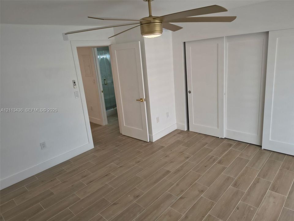 Wood-finish tile flooring, recessed LED ceiling fan with light fixture, and shaker-style interior doors