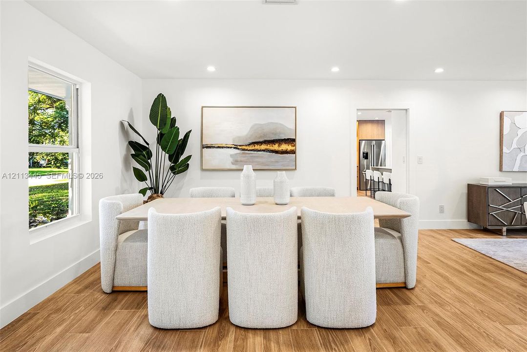 Bright, neutral interior featuring wood-finish flooring, recessed lighting, and large-format window