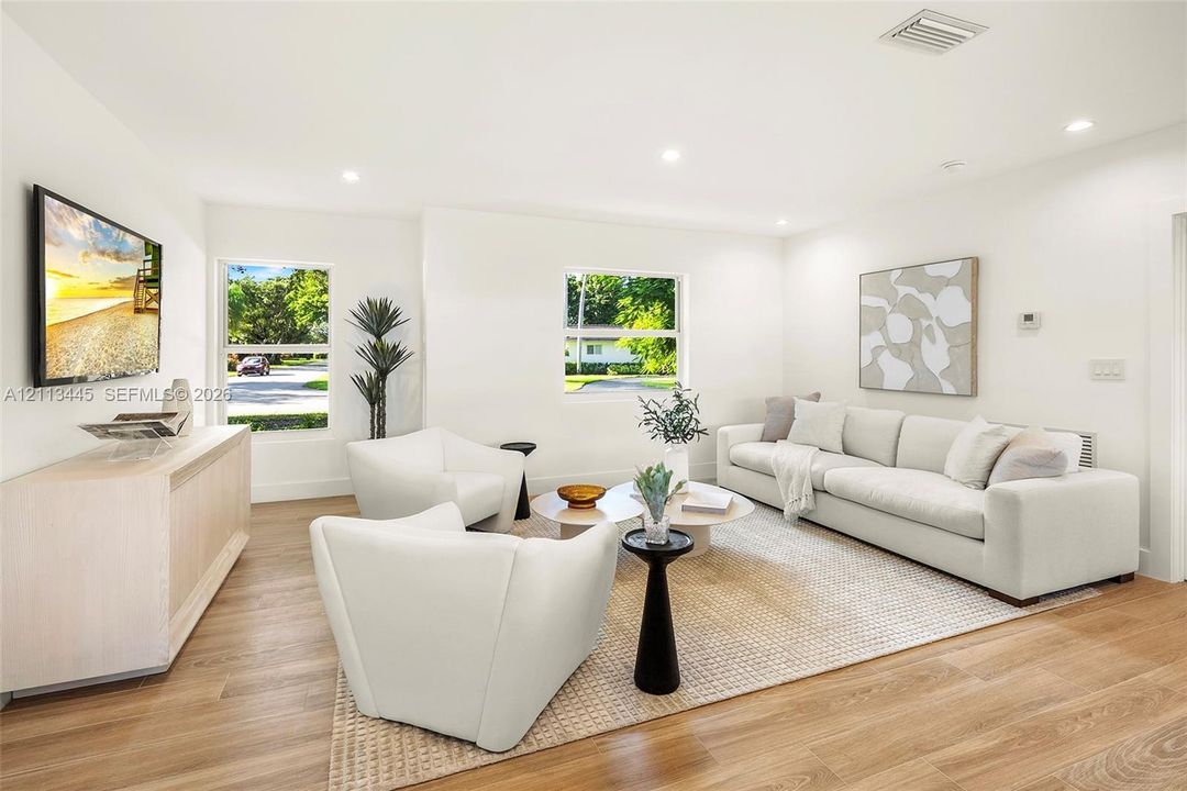 Living area featuring wood-finish flooring, recessed lighting, and multiple windows