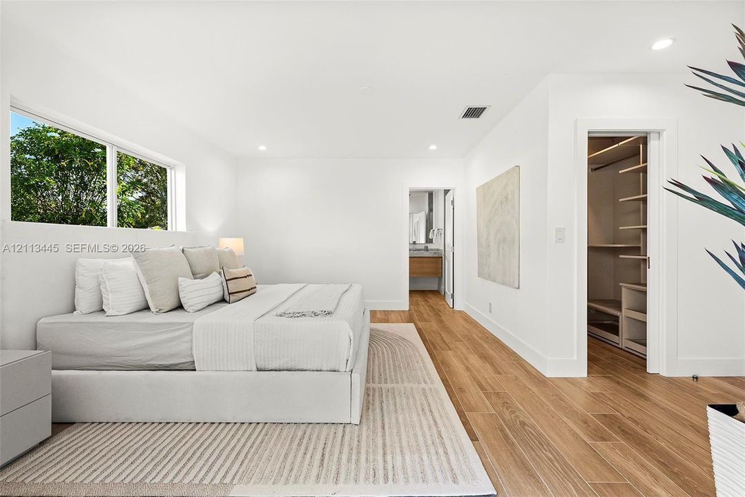 Interior space featuring wood-finish flooring, recessed lighting, and a walk-in closet with built-in shelving
