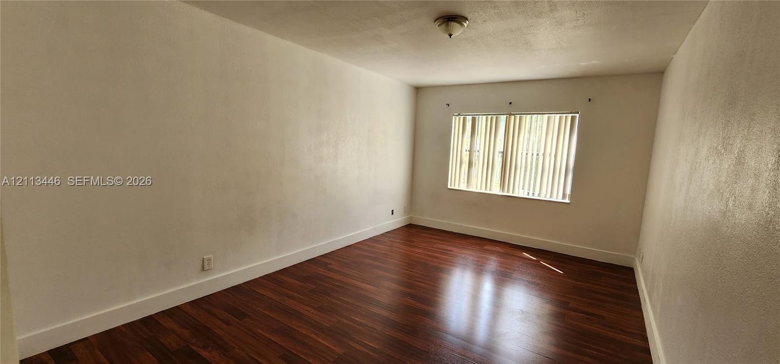 Room featuring dark wood-finish flooring, white walls, and a recessed ceiling light