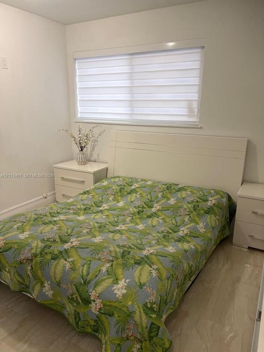 Neutral-toned walls, light-toned flooring, and window featuring horizontal light-filtering blinds