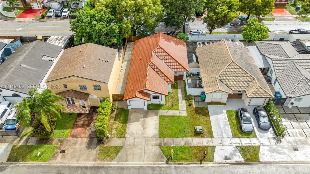 Single-story residence featuring a clay tile roof, stucco exterior, attached one-car garage, and a grass lawn