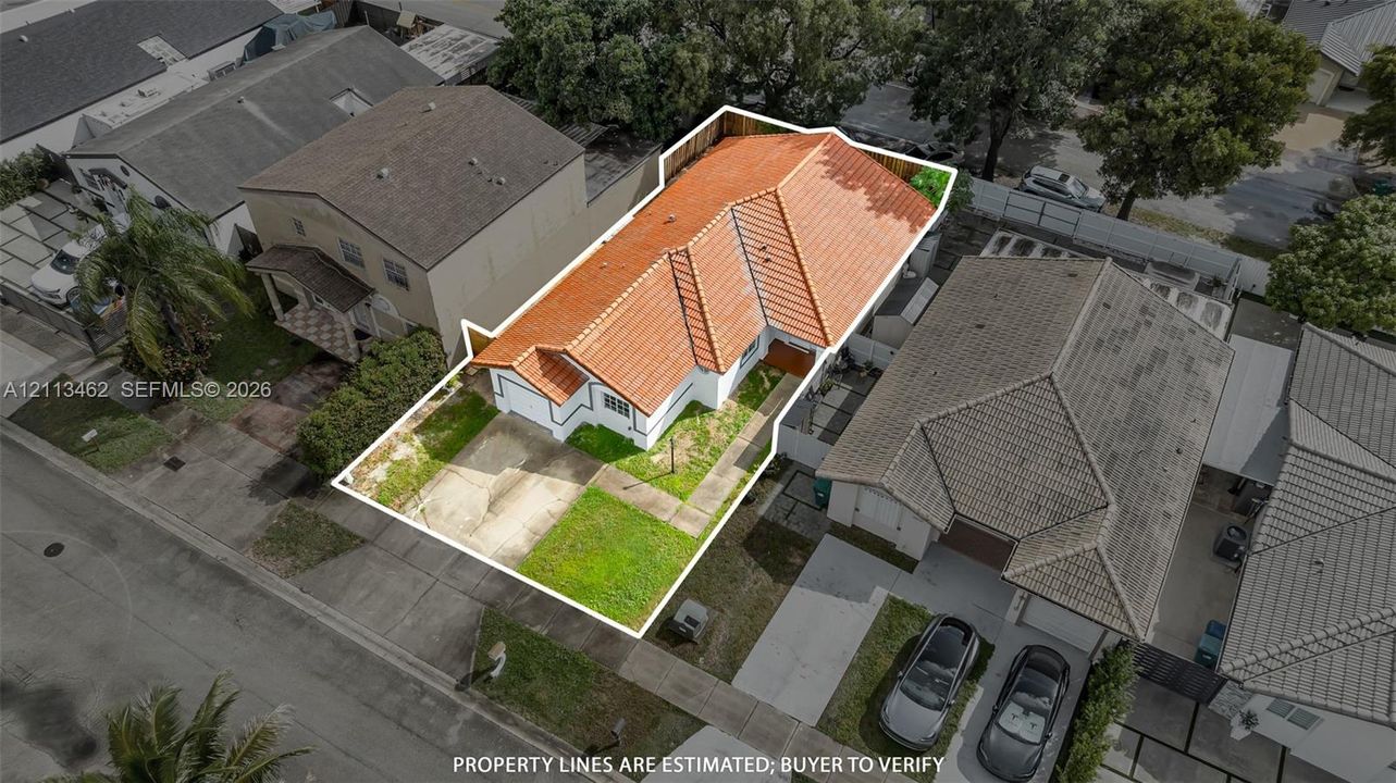 Aerial perspective of the residential property featuring a pitched roof, exterior stucco siding, and a paved driveway
