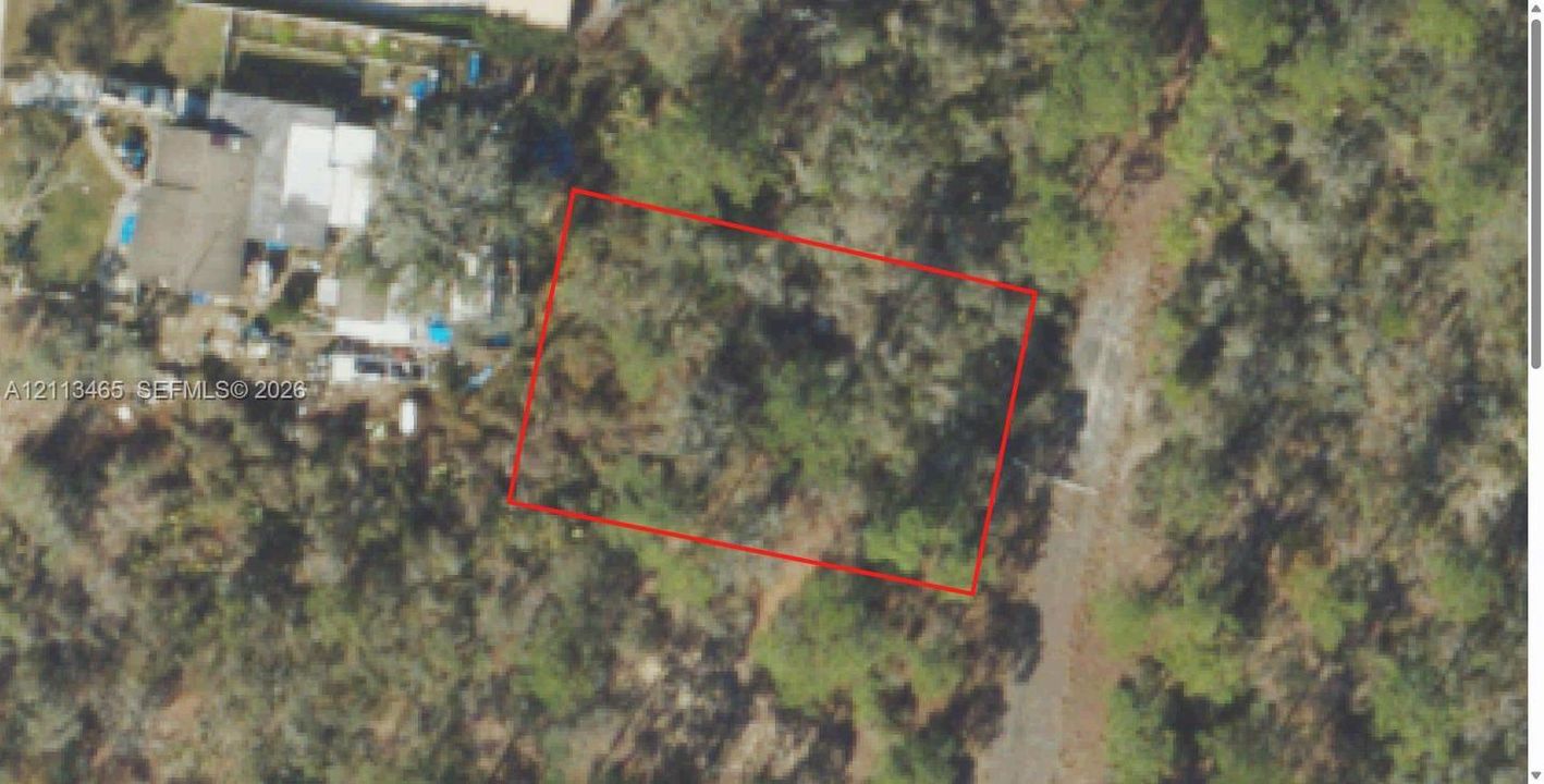 Aerial view (USDA NAIP public-domain imagery) with the approximate lot outline. The platted Blue Heaven Dr right-of-way to the east (right) is not constructed; homes on Twilight Dr are to the west. Lines are approximate, not a survey.