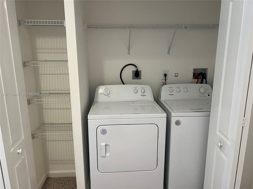 Laundry space featuring built-in wire shelving and dedicated hookups for a washer and dryer