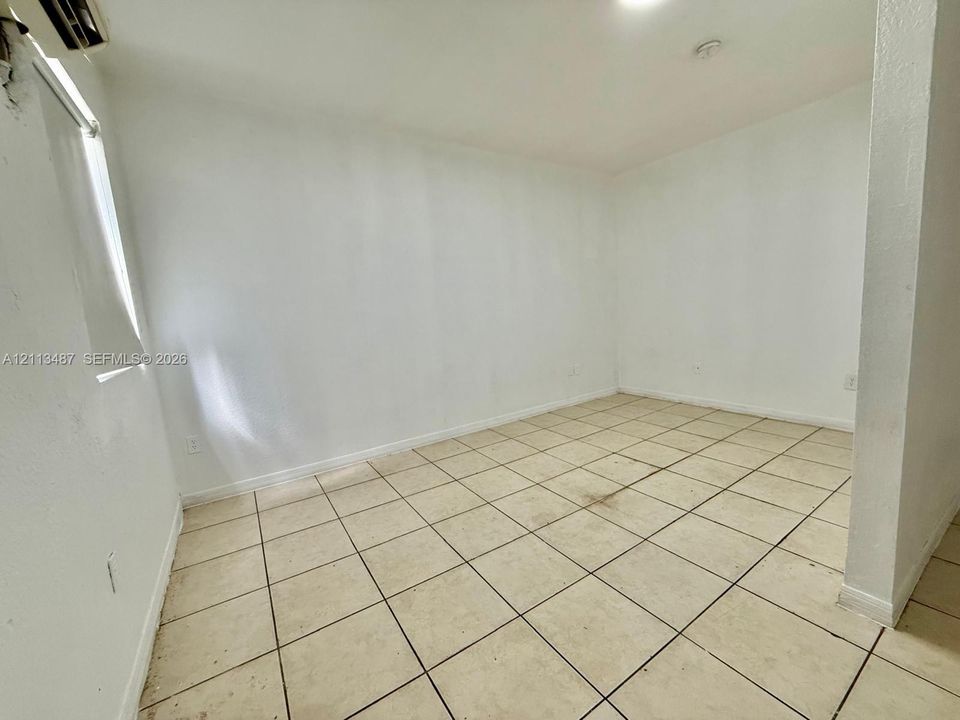 Neutral-toned ceramic tile flooring, clean white walls, and a recessed ceiling lighting fixture