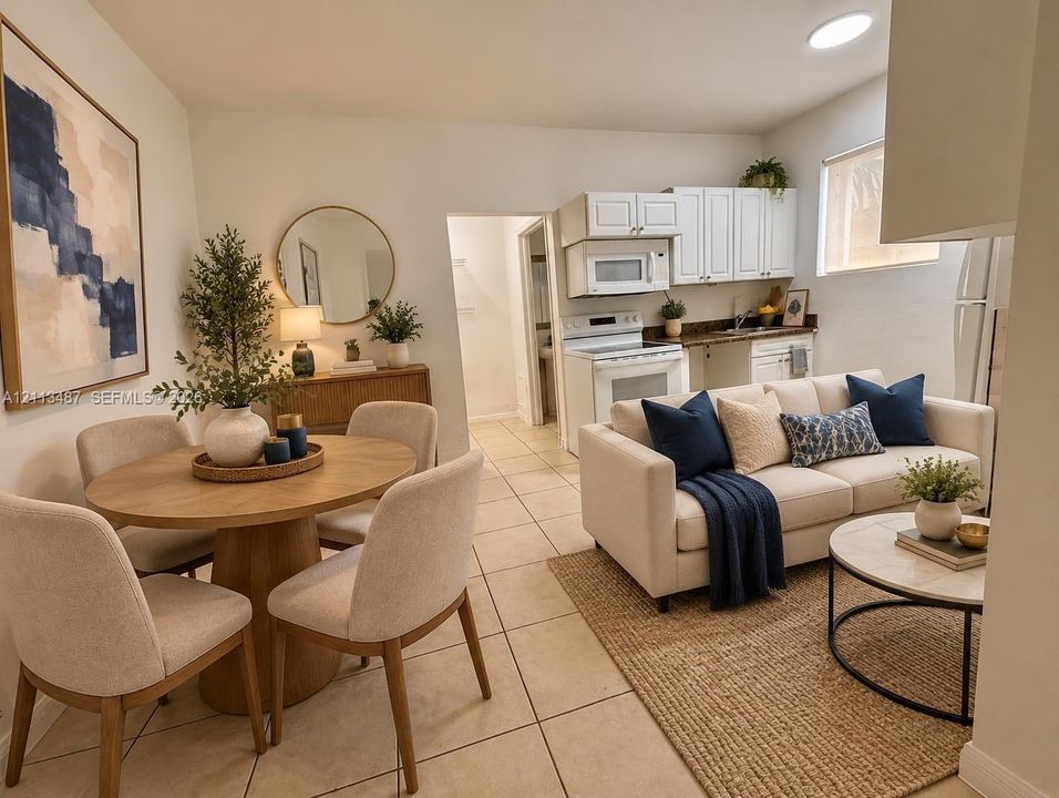 Open-concept interior featuring light-toned tile flooring, white cabinetry, built-in microwave, and recessed ceiling lighting