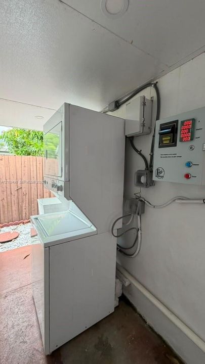 Stacked laundry unit with utility control panel and recessed ceiling lighting